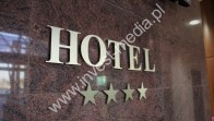 logo hotelu na wejściu i recepcji